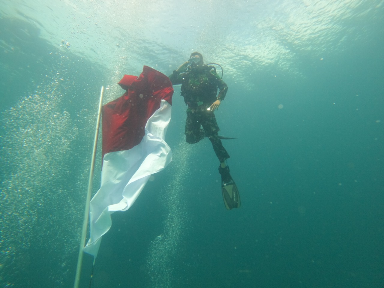 PENGIBARAN DAN PEMBENTANGAN BENDERA MERAH PUTIH SEPANJANG 35 METER DI KEDLAMAN 9 METER OLEH NABIRE DIVE COMMUNITY BESERTA TNI – POLRI DI KABUPATEN NABIRE