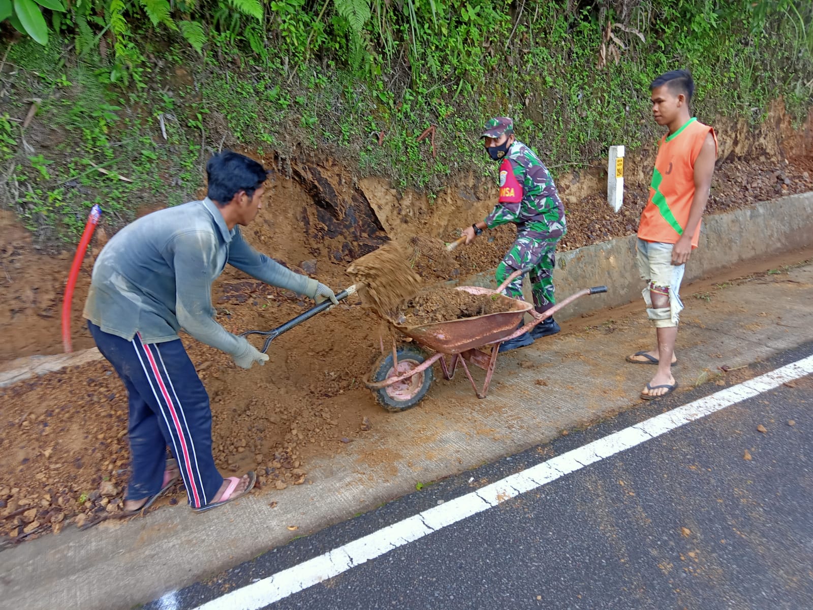 Babinsa Koramil 05/Linge Bersama warga Bersihkan Tanah longsor