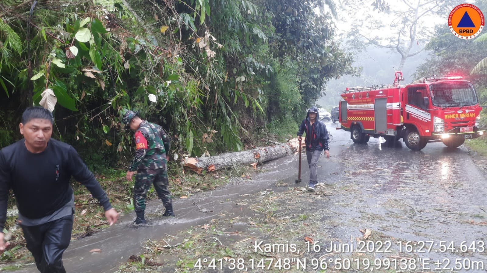 Babinsa, BPBD Dan Warga Berjibaku Bersihkan Pohon Tumbang Di Jalan Lintas Nasional