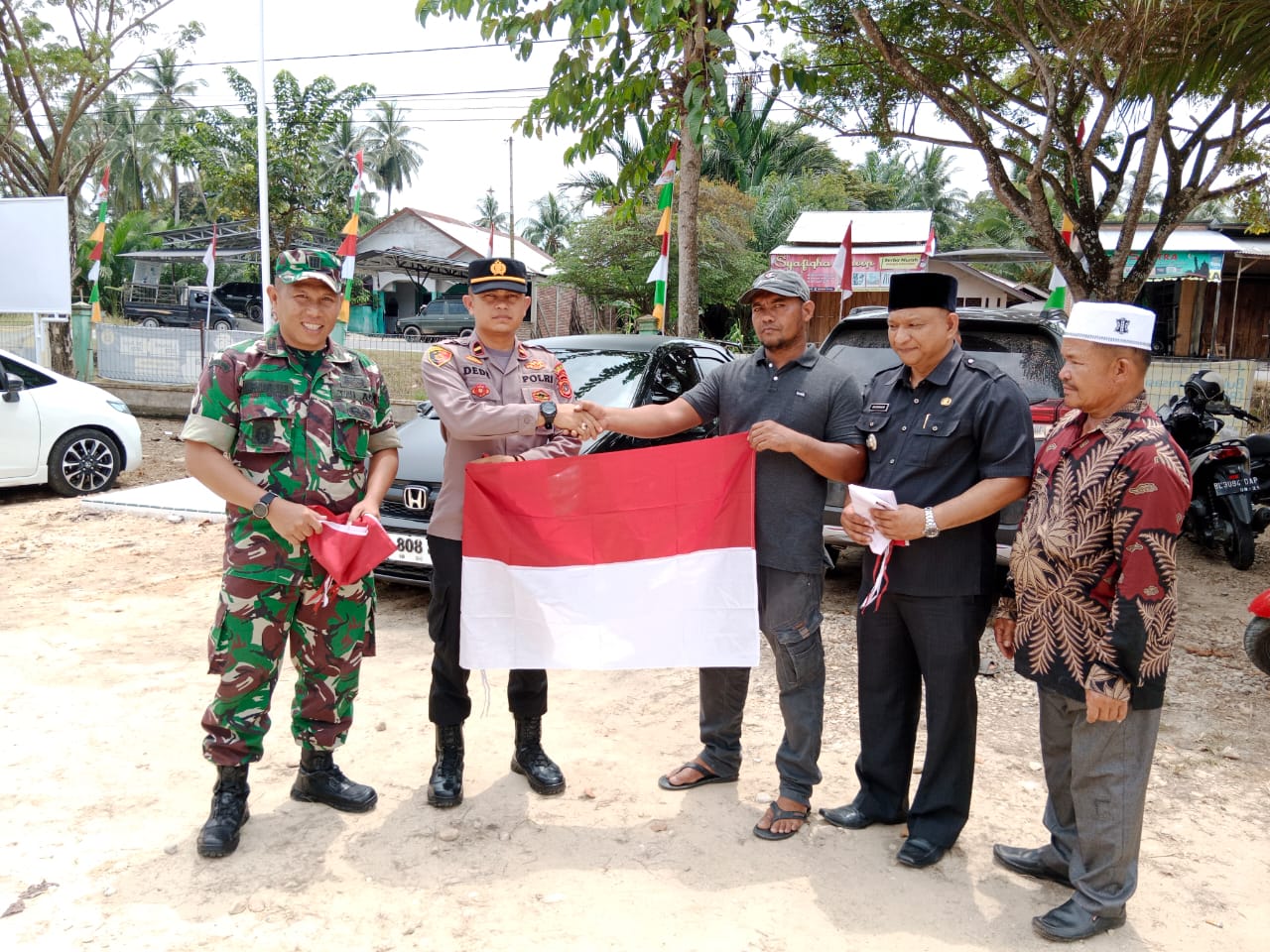 Tanamkan Rasa Nasionalisme, Kapolsek Peureulak Barat Bersama Muspika Bagikan Bendera Merah Putih ke Masyarakat.