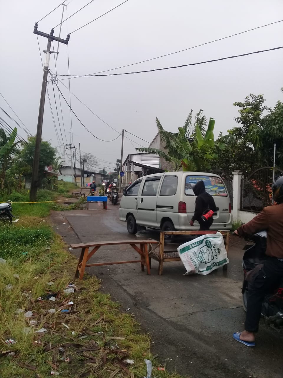 MENENGOK JALAN YANG BERLOBANG KARENA HUJAN SEMALAM.”