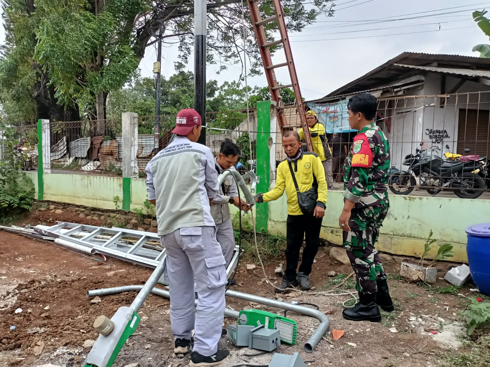 Babinsa Bersama Sudin Bina Marga Pasang Lampu Jalan Kampung