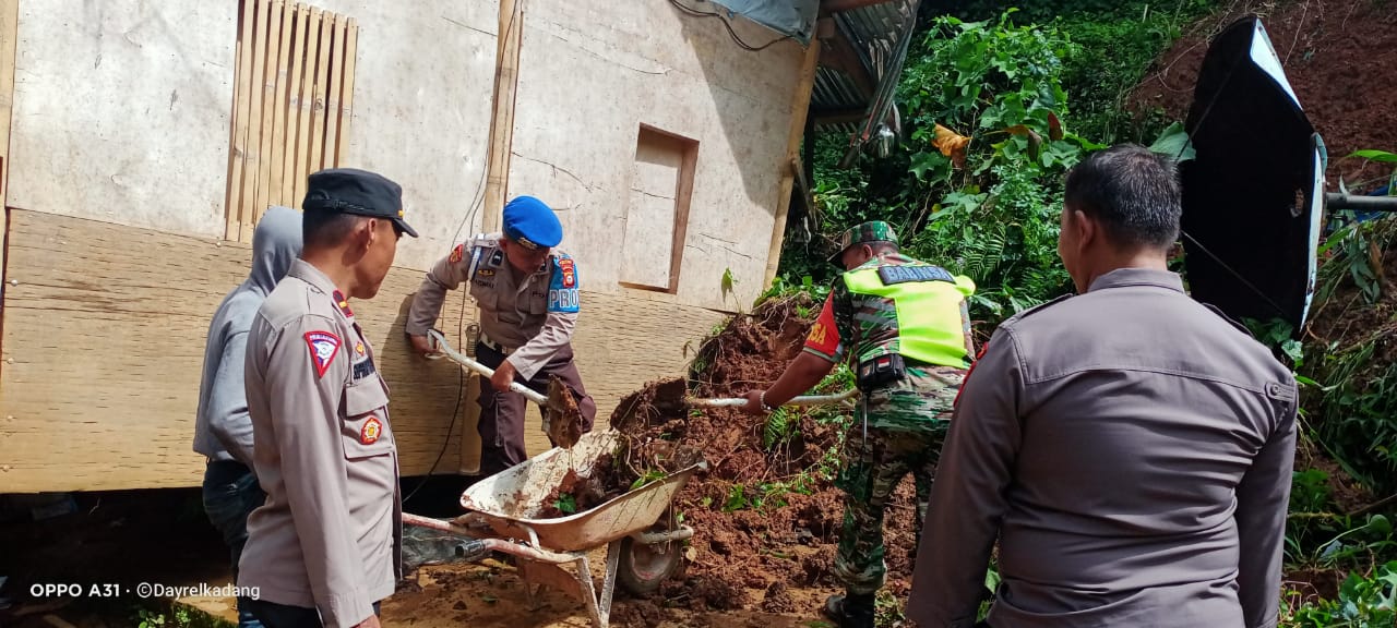 Polsek Sopai Hadir Bantu Masyarakat Bersihkan Material Longsor Yang Menimpa Salah Satu Rumah Warga