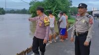 Respon Cepat Anggota Polsek Pabedilan Polresta Cirebon Polda Jabar dalam Ciptakan situasi yang aman dan kondusif di jalan umum yang tergenang air dengan mengatur arus lalu lintas