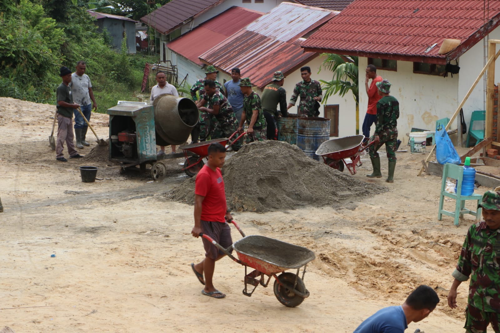 Kompak ! Satgas TMMD bersama Warga Racik Bahan Materil Cor Lapangan Voli