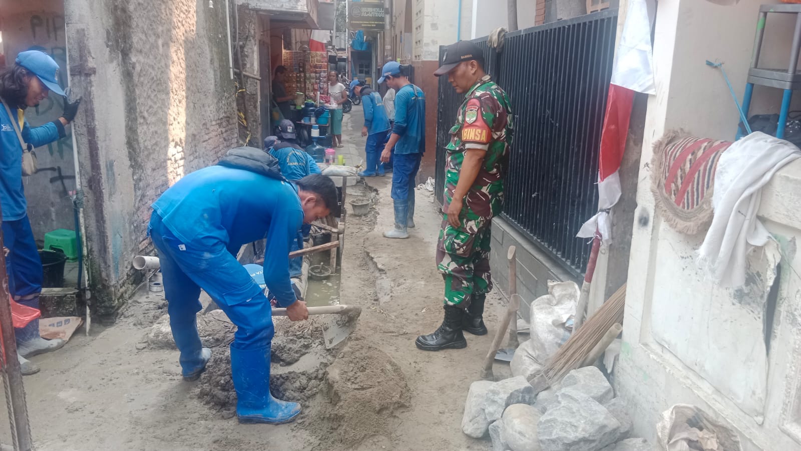 Antisipasi Masuk Musim Penghujan Babinsa 08/Johar Baru Bersama Suku Dinas Tata Air Memperbaiki Saluran Air Dipemukiman Warga Binaan