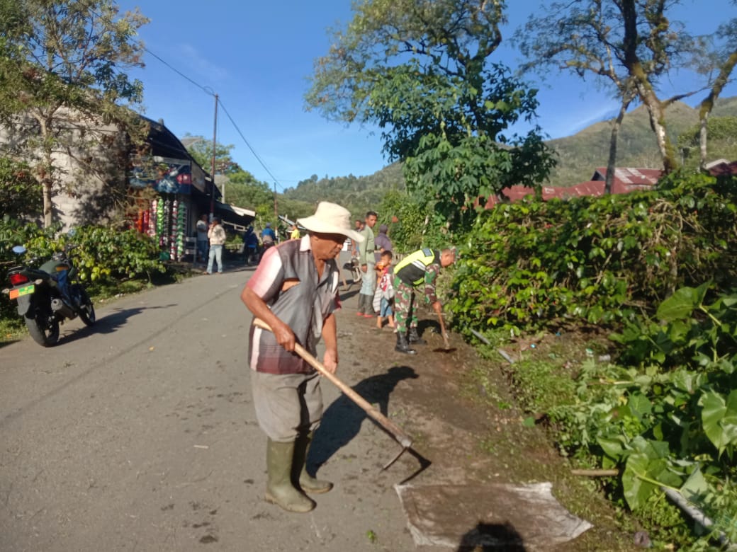 Peduli Lingkungan, Babinsa Bersama Warga Bersihkan Rumput Kanan Kiri Jalan